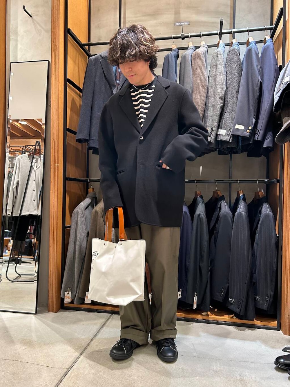 ホワイト系のトートバッグ、ブラック系のTシャツ/カットソー、ブラック系のその他アウターを着用したメンズの秋コーディネートの2枚目の写真
