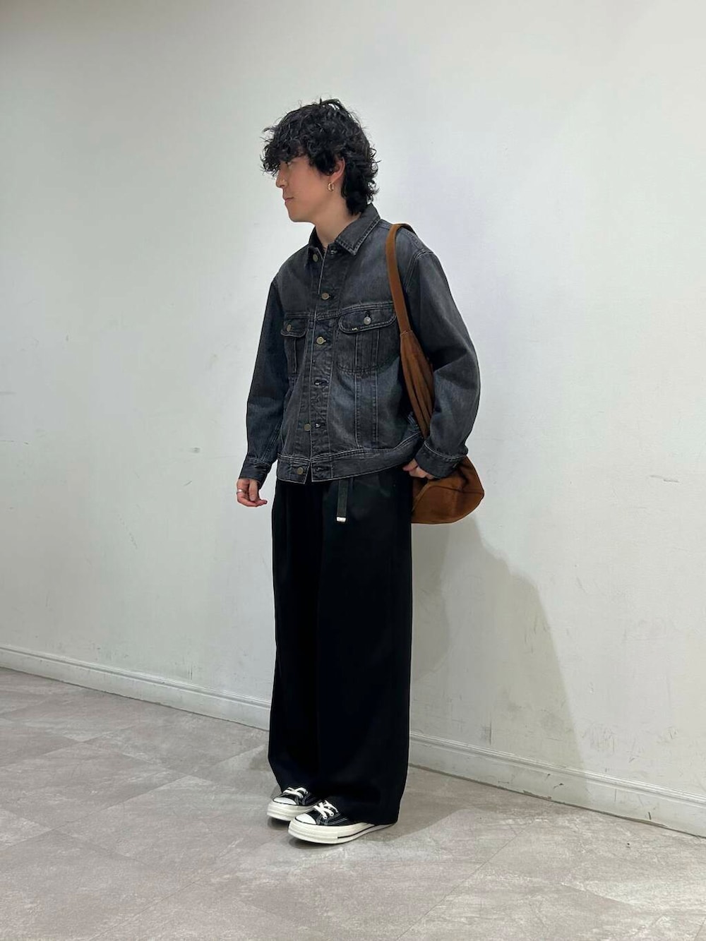 ブラウン系のトートバッグ、ブラック系のデニムジャケット、ブラック系のその他パンツを着用したメンズの夏コーディネートの2枚目の写真