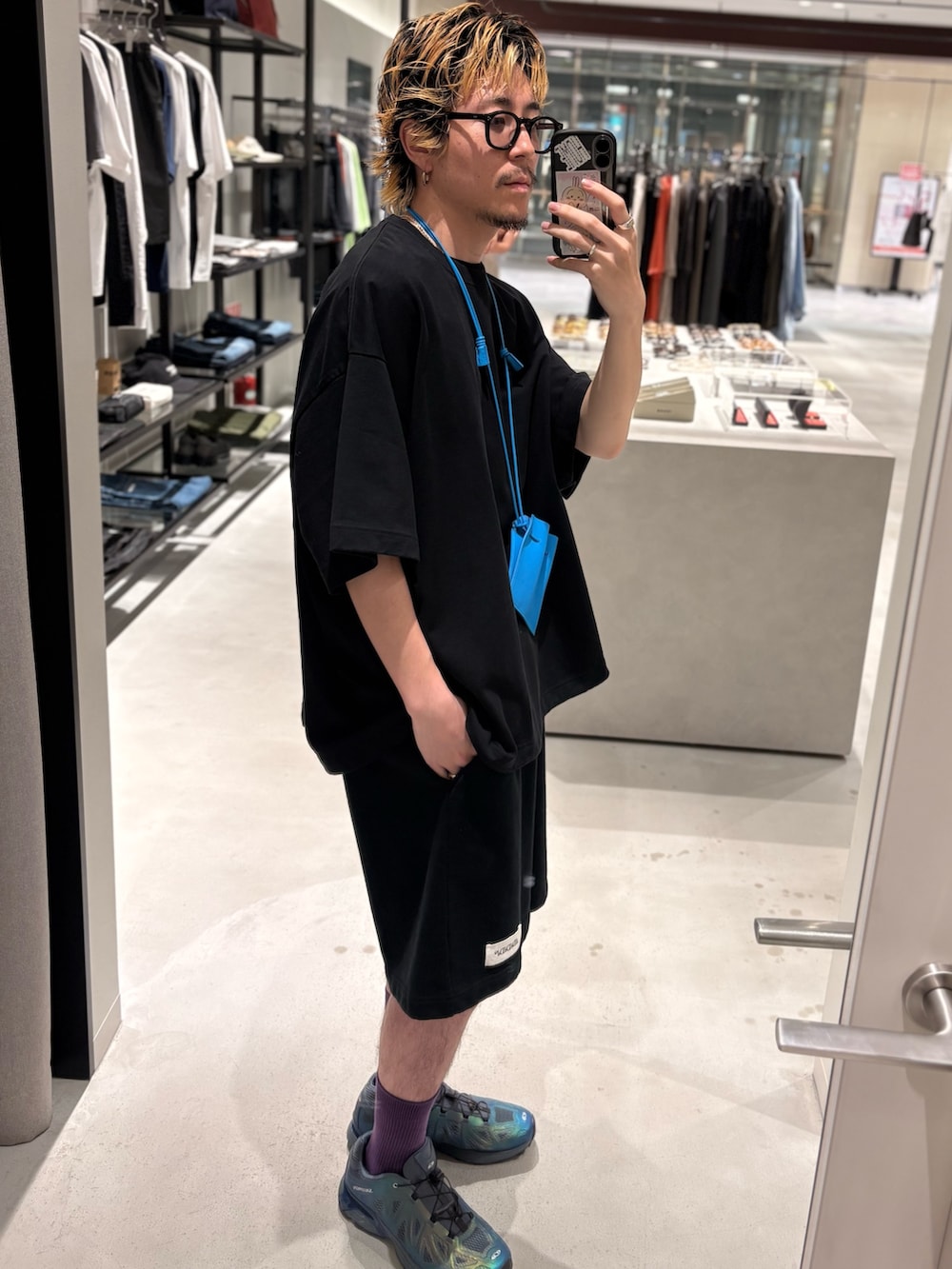 ブラック系のTシャツ/カットソー、ブラック系のその他パンツ、ブルー系のポーチを着用したメンズの夏コーディネートの3枚目の写真