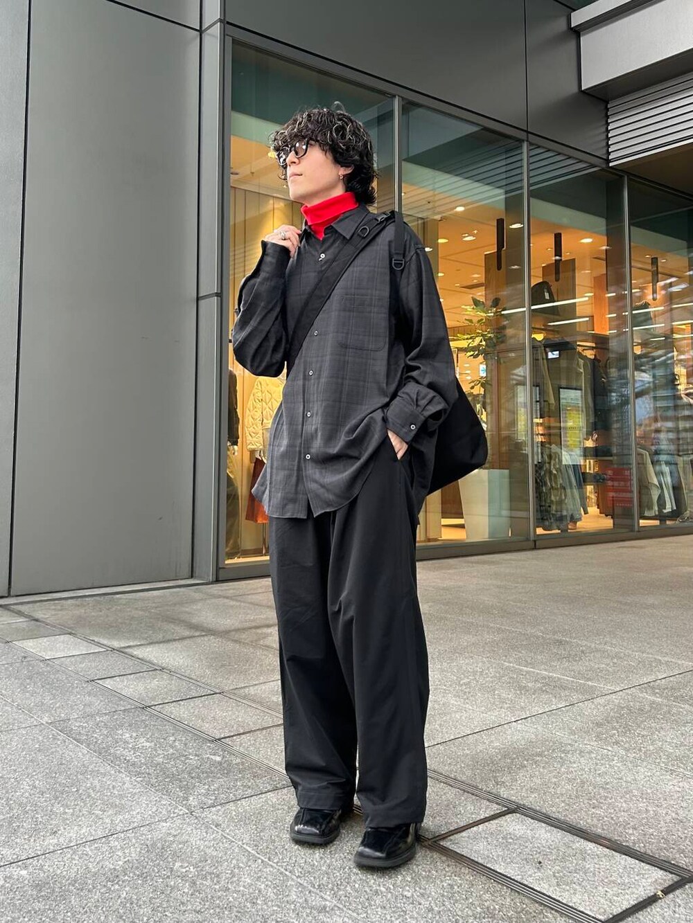 レッド系のTシャツ/カットソー、ブラック系のその他パンツ、ブラック系のトートバッグを着用したメンズの秋コーディネートの2枚目の写真