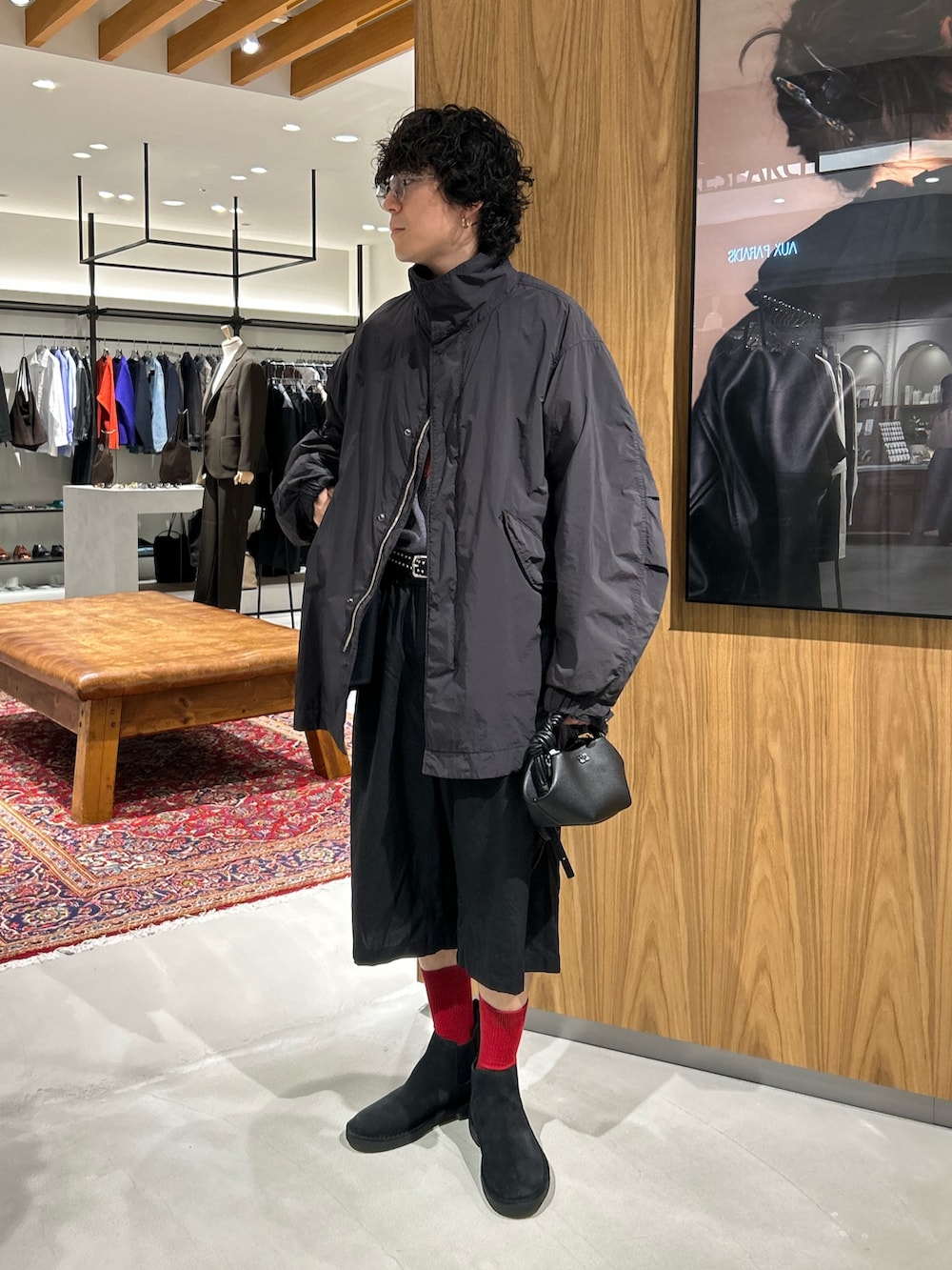 ブラック系のモッズコート、ブラック系のハンドバッグ、ブラック系のその他シューズを着用したメンズの秋コーディネートの2枚目の写真