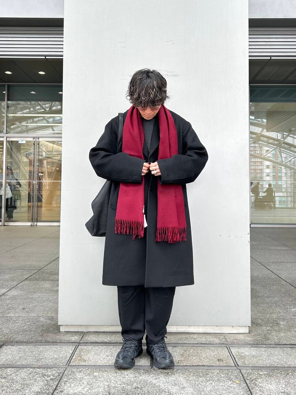 ブラック系のチェスターコート、ホワイト系のシャツ/ブラウス、グレー系のニット/セーターを着用したメンズの秋コーディネートの2枚目の写真