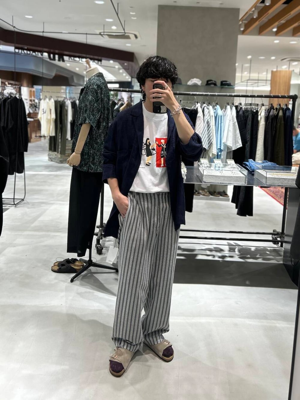 ベージュ系のサンダル、ブラック系のその他パンツ、ホワイト系のTシャツ/カットソーを着用したメンズの夏コーディネートの2枚目の写真