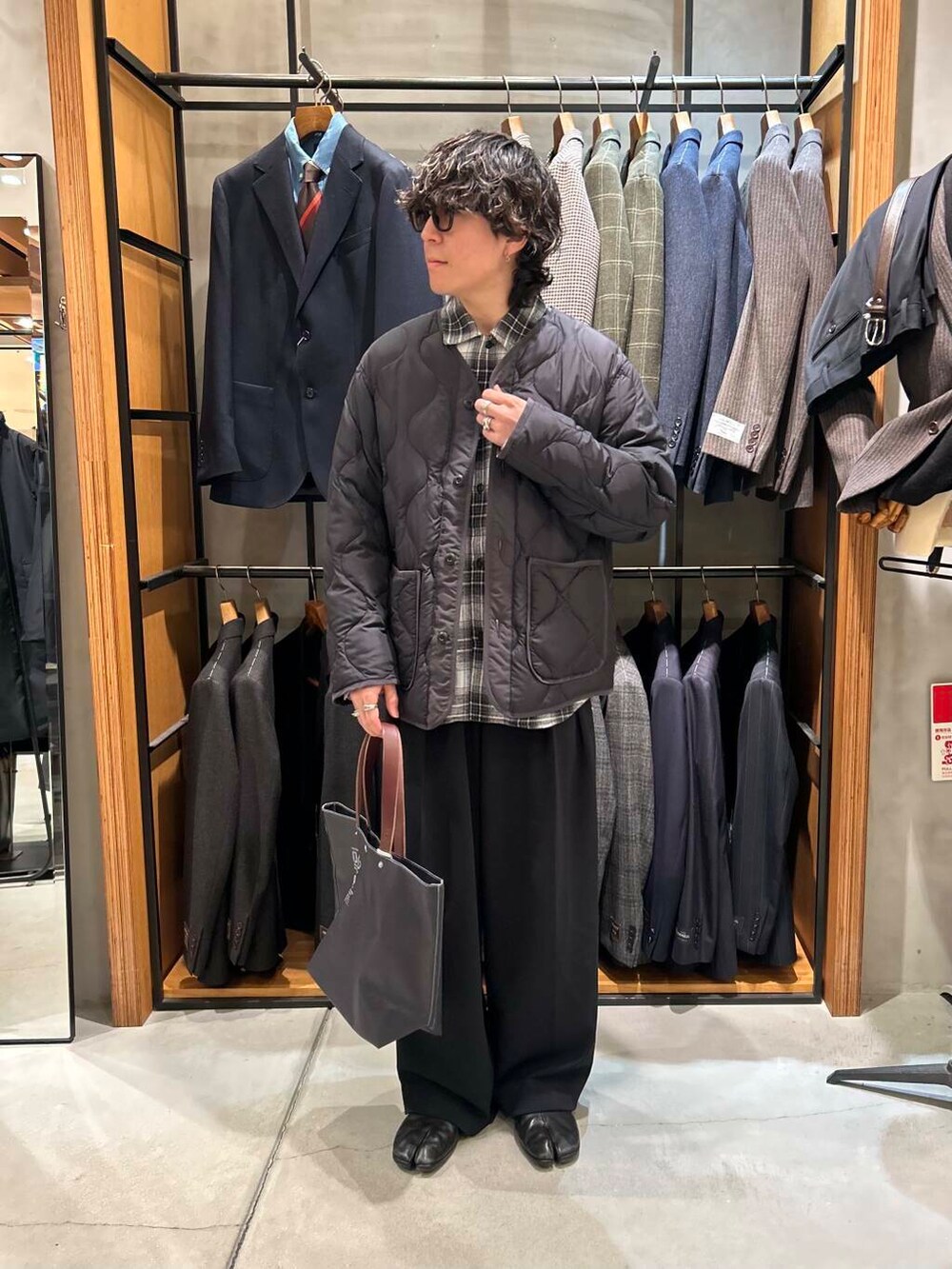 ブルー系のトートバッグ、ブラック系のダウンジャケット/コート、ブラック系のシャツ/ブラウスを着用したメンズの冬コーディネートの2枚目の写真