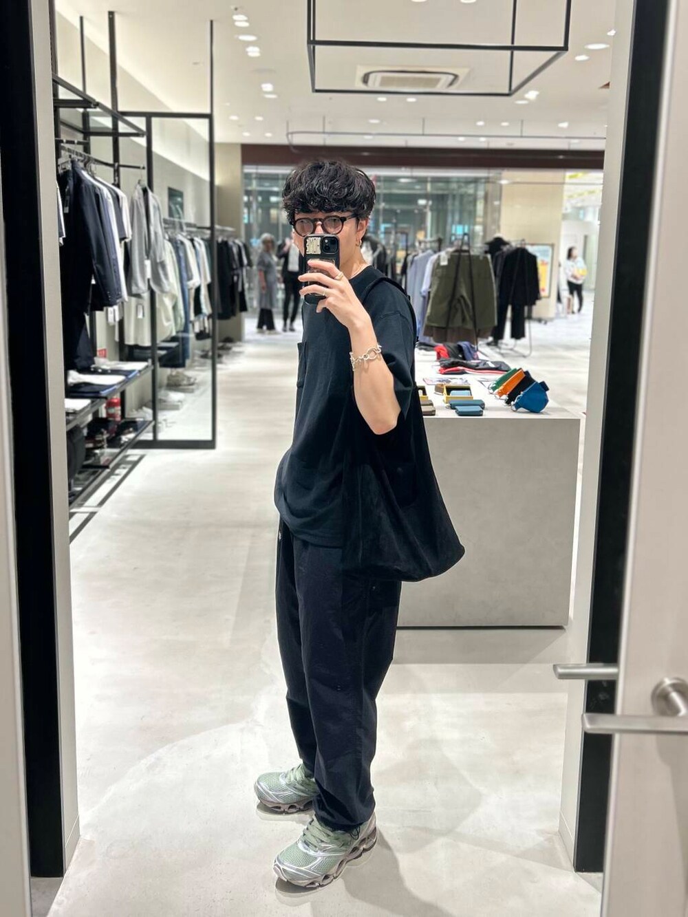 ブラック系のその他パンツ、グリーン系のスニーカー、ブラック系のTシャツ/カットソーを着用したメンズの春コーディネートの3枚目の写真