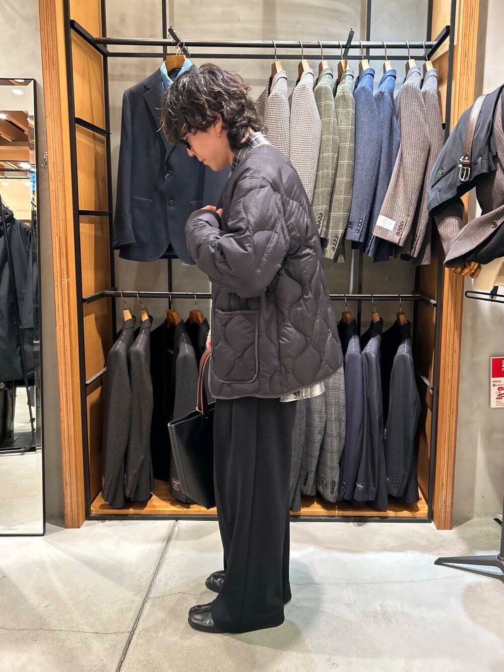 ブルー系のトートバッグ、ブラック系のダウンジャケット/コート、ブラック系のシャツ/ブラウスを着用したメンズの冬コーディネートの3枚目の写真