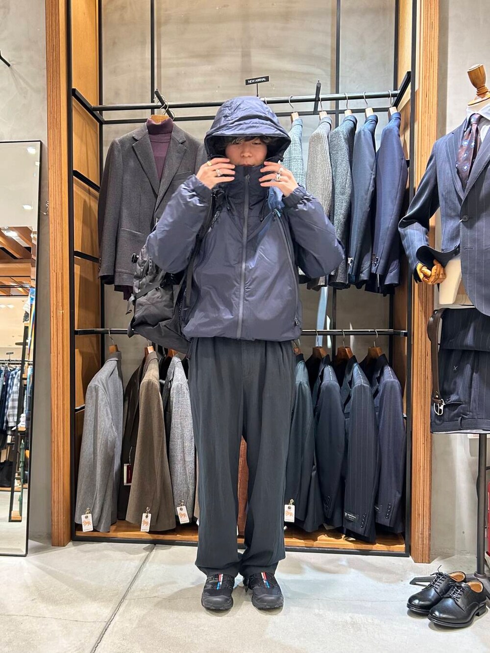 ブラック系のバックパック/リュック、ブラック系のスニーカー、ブルー系のダウンジャケット/コートを着用したメンズの秋コーディネートの3枚目の写真