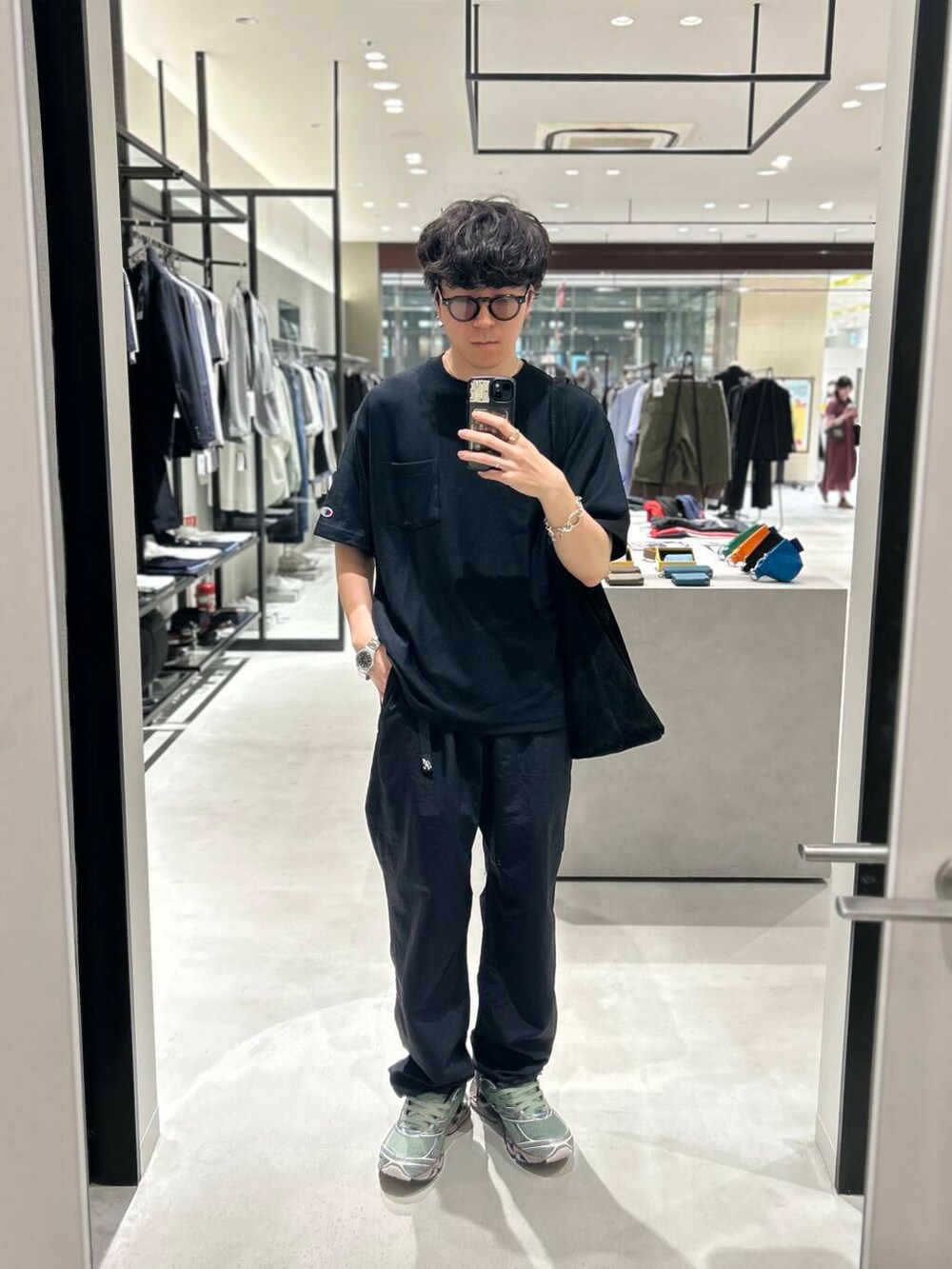 ブラック系のその他パンツ、グリーン系のスニーカー、ブラック系のTシャツ/カットソーを着用したメンズの春コーディネートの2枚目の写真