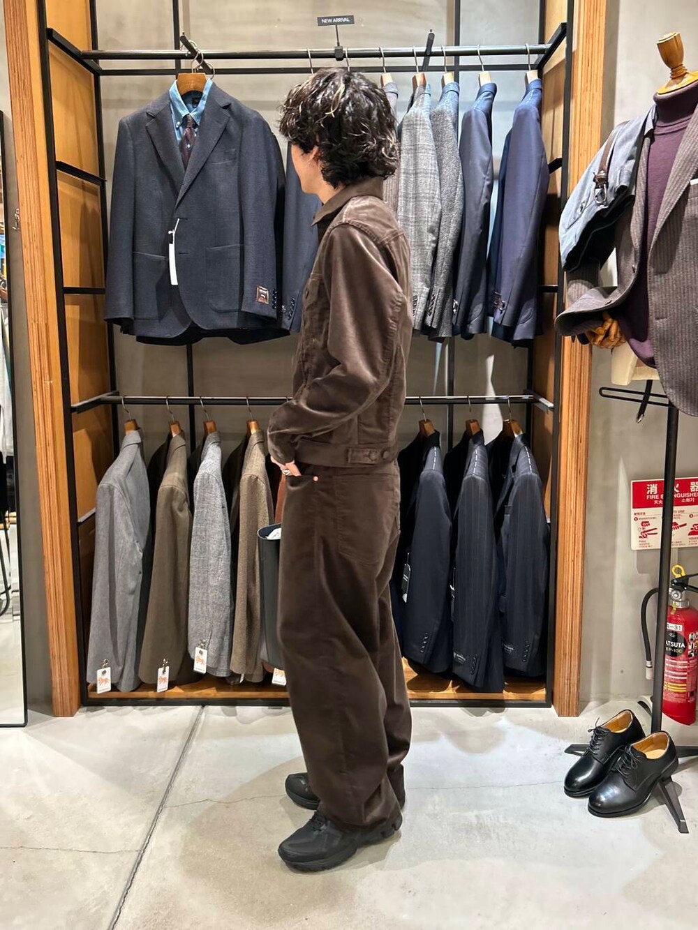 ブラック系のトートバッグ、ブラウン系のその他アウター、ブラウン系のその他パンツを着用したメンズの秋コーディネートの3枚目の写真