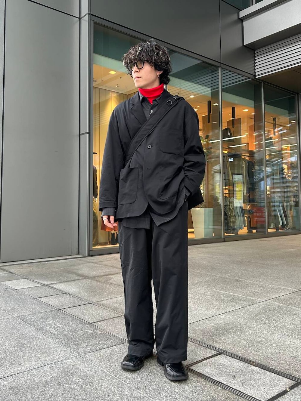 レッド系のTシャツ/カットソー、ブラック系のその他パンツ、ブラック系のその他アウターを着用したメンズの秋コーディネートの3枚目の写真