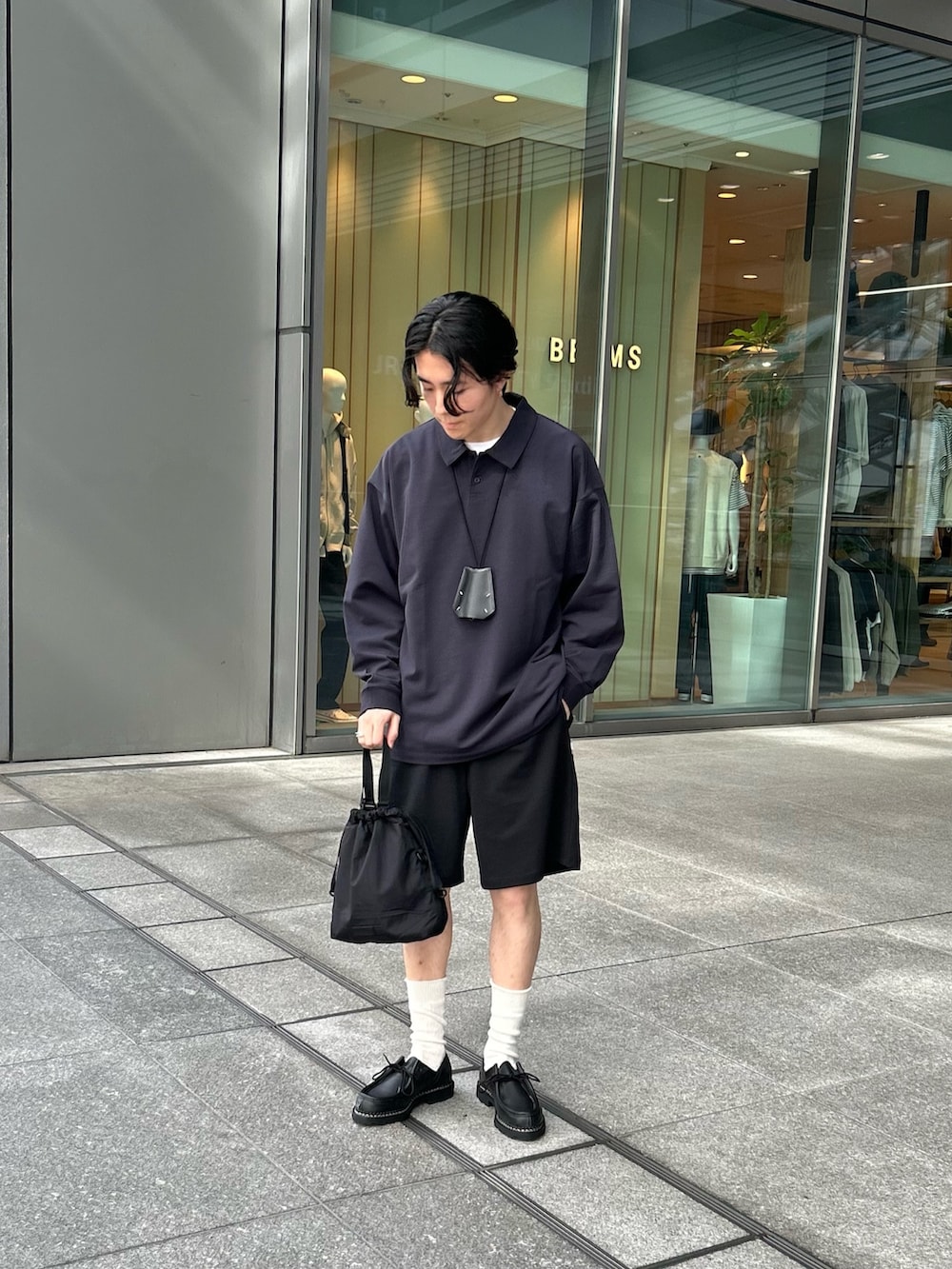 ブルー系のポロシャツ、ブラック系のその他パンツ、ブラック系のブーツを着用したメンズの春コーディネートの3枚目の写真