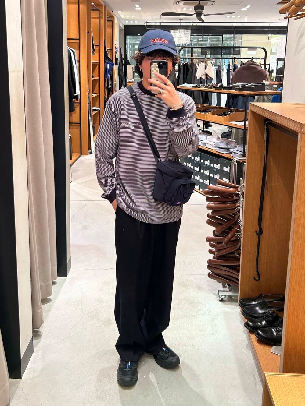 ブルー系のスラックス、ブラック系のスニーカー、その他のTシャツ/カットソーを着用したメンズの夏コーディネートの2枚目の写真