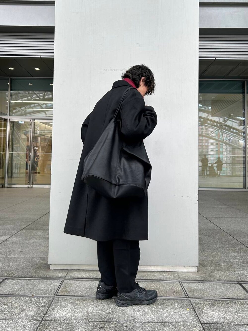 ブラック系のチェスターコート、ホワイト系のシャツ/ブラウス、グレー系のニット/セーターを着用したメンズの秋コーディネートの4枚目の写真