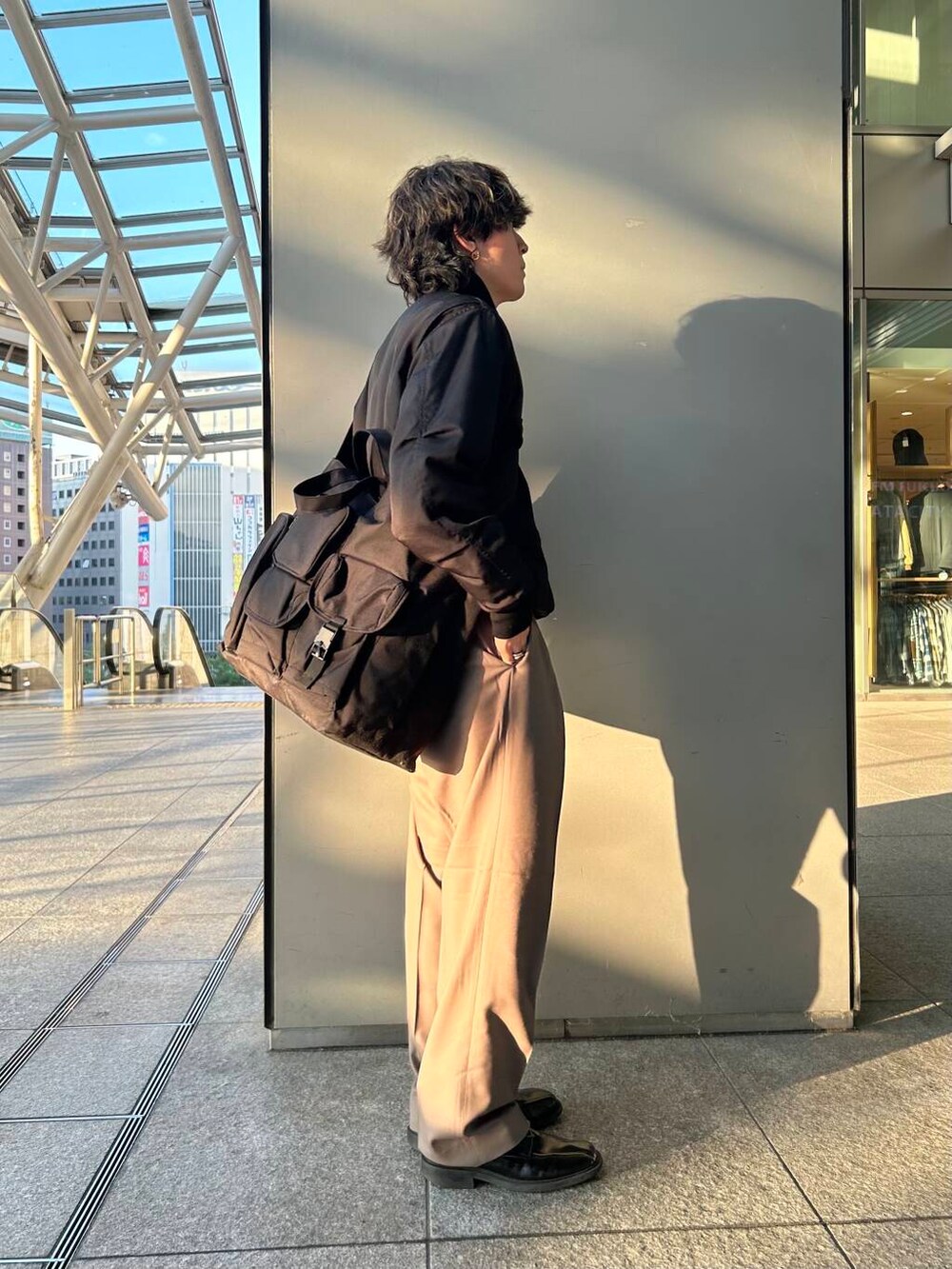 ブラック系のトートバッグ、ベージュ系のその他パンツ、ブラック系のその他アウターを着用したメンズの秋コーディネートの3枚目の写真