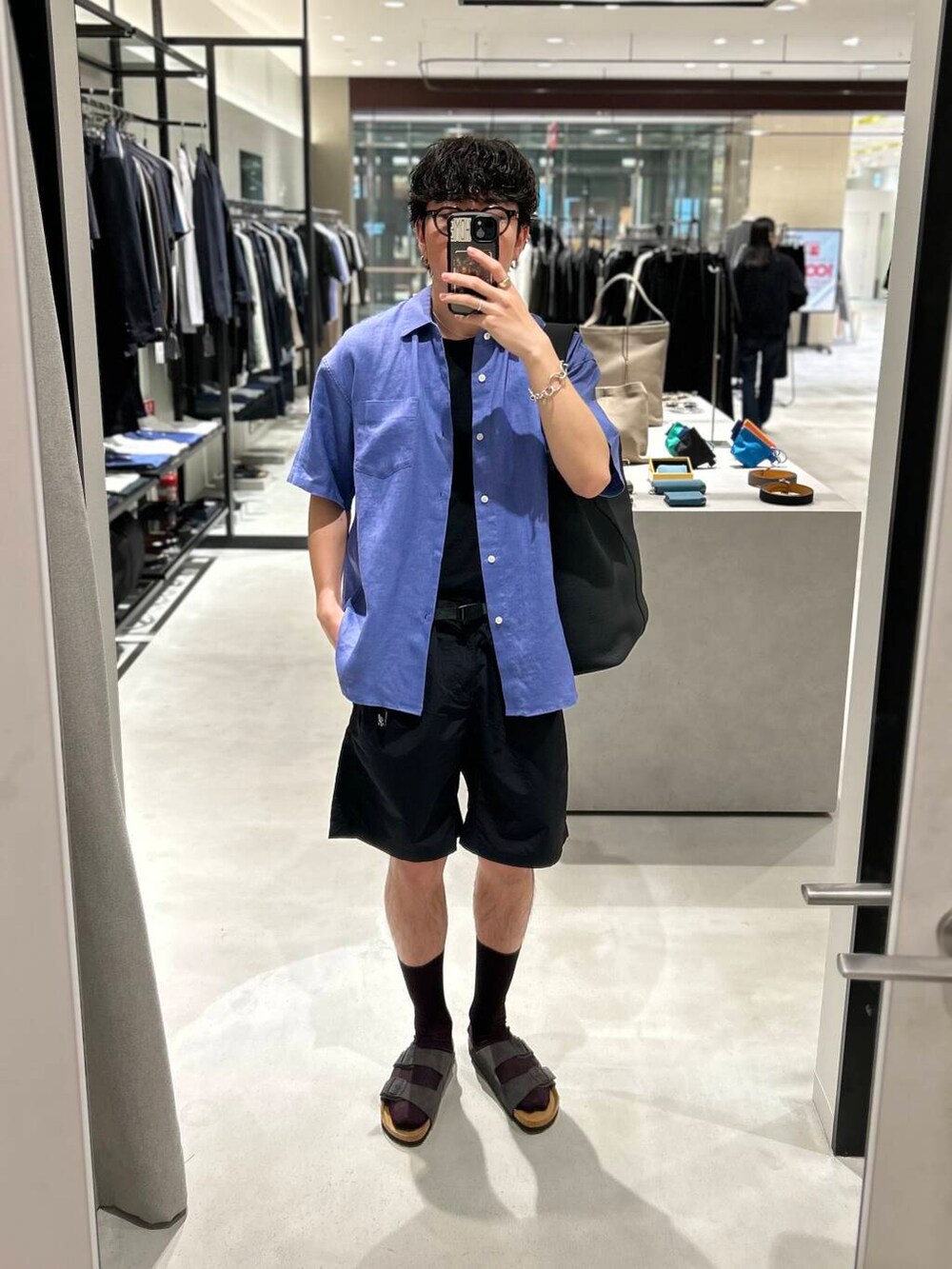 ブラック系のその他パンツ、グレー系のサンダル、ブラック系のトートバッグを着用したメンズの春コーディネートの3枚目の写真