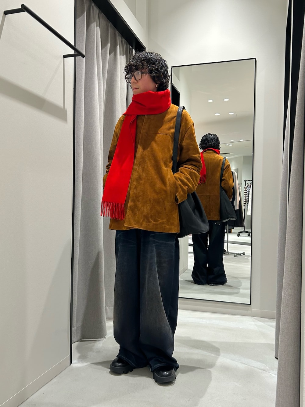 ブラウン系のその他アウター、レッド系のマフラーを着用したメンズの冬コーディネートの3枚目の写真