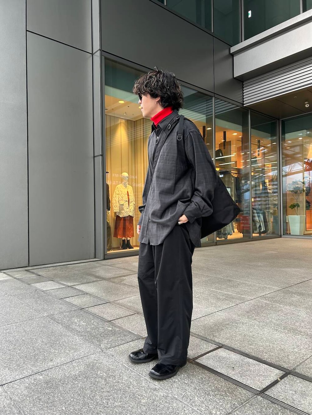 レッド系のTシャツ/カットソー、ブラック系のその他パンツ、ブラック系のトートバッグを着用したメンズの秋コーディネートの3枚目の写真