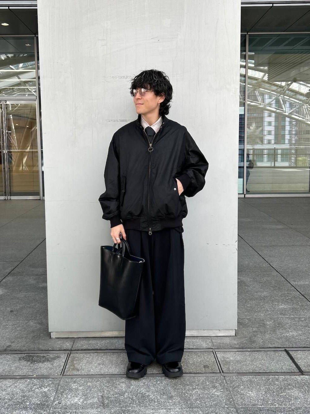 ブラック系のトートバッグ、ブラック系のブルゾン、グレー系のネクタイを着用したメンズの秋コーディネートの2枚目の写真