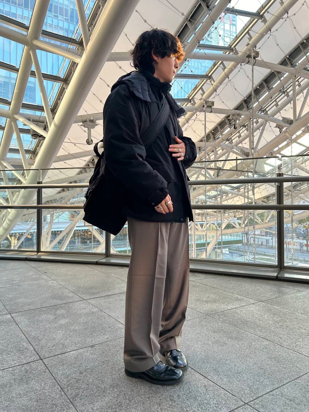 ブラック系のダウンジャケット/コート、ブラック系のトートバッグ、ベージュ系のその他パンツを着用したメンズの秋コーディネートの2枚目の写真