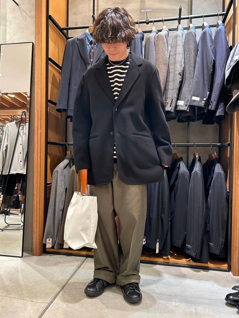 ホワイト系のトートバッグ、ブラック系のTシャツ/カットソー、ブラック系のその他アウターを着用したメンズの秋コーディネートの3枚目の写真