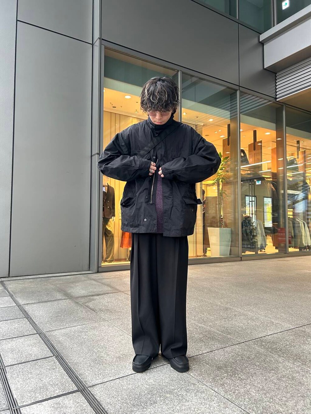 ブラック系のナイロンジャケット、ブラック系のその他シューズ、パープル系のニット/セーターを着用したメンズの秋コーディネートの2枚目の写真