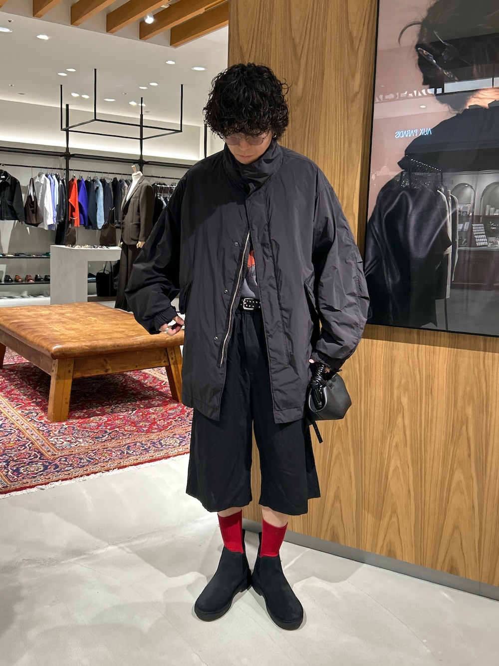 ブラック系のモッズコート、ブラック系のハンドバッグ、ブラック系のその他シューズを着用したメンズの秋コーディネートの4枚目の写真