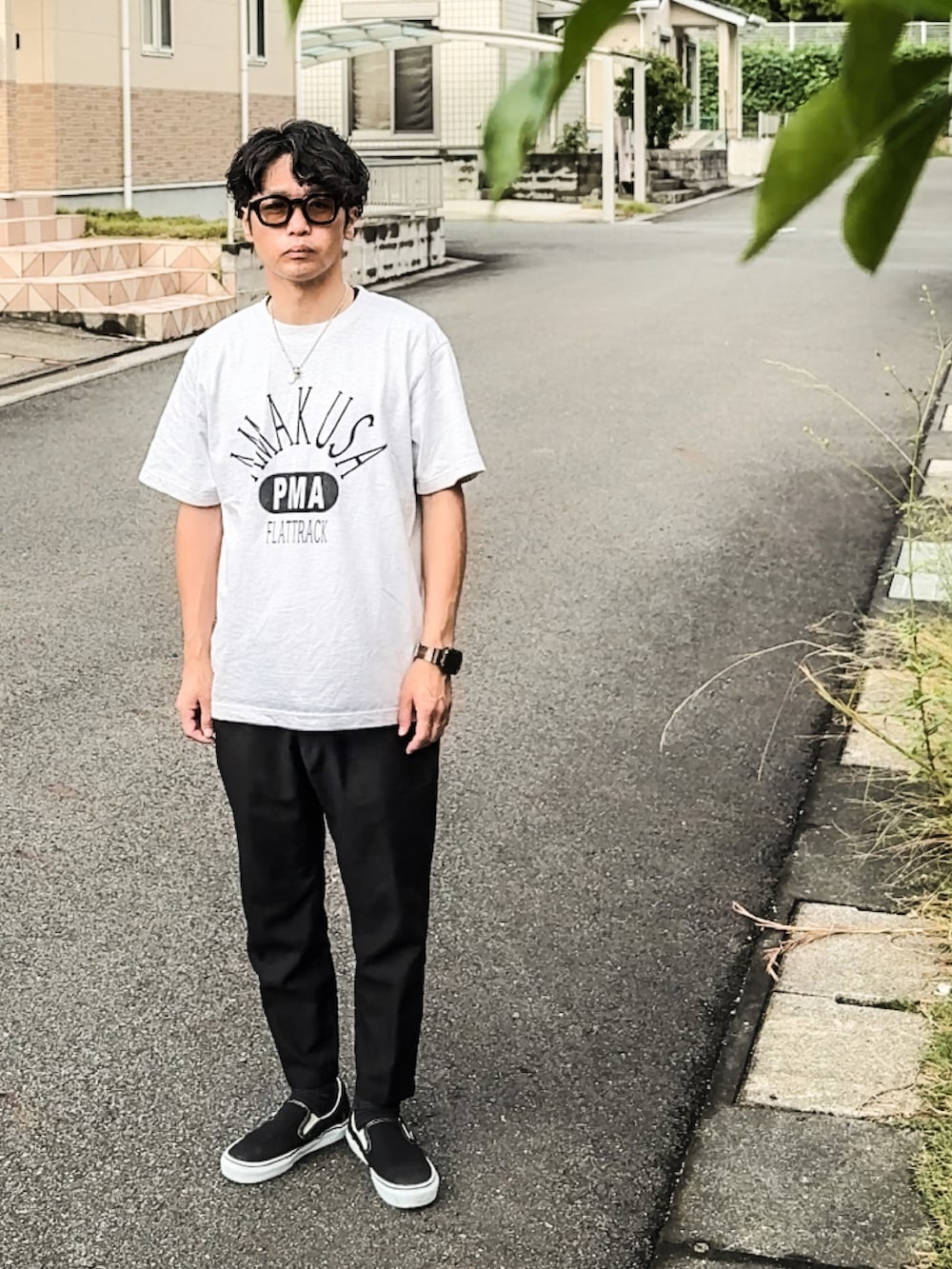 ブラック系のスラックス、ブラック系のスリッポン、ブラウン系のサングラスを着用したメンズの秋コーディネートの2枚目の写真