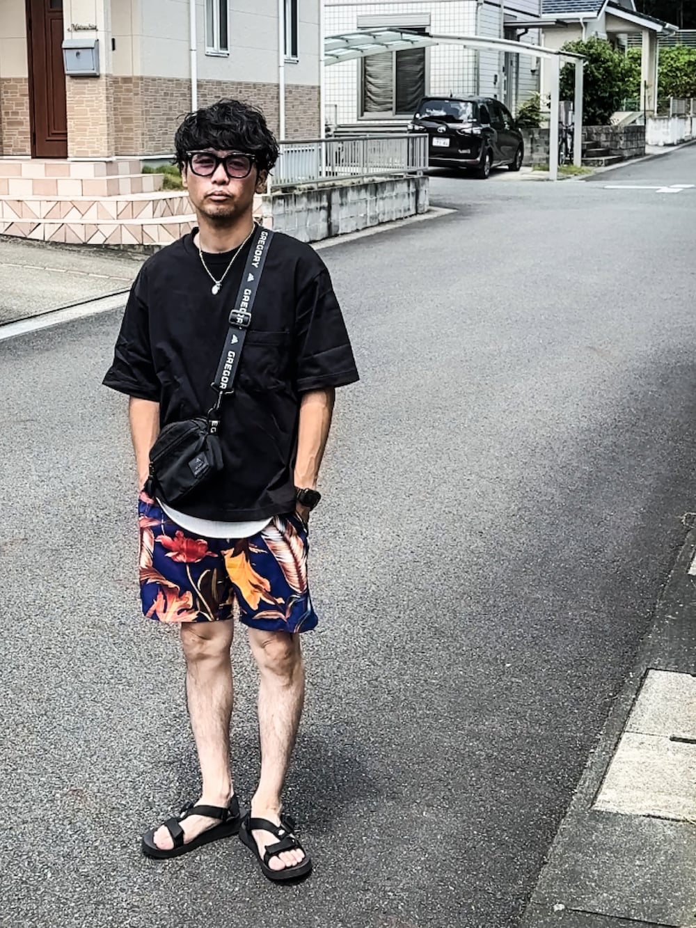 ブラック系のTシャツ/カットソー、ブルー系のその他パンツ、ブラック系のサンダルを着用したメンズの夏コーディネートの3枚目の写真