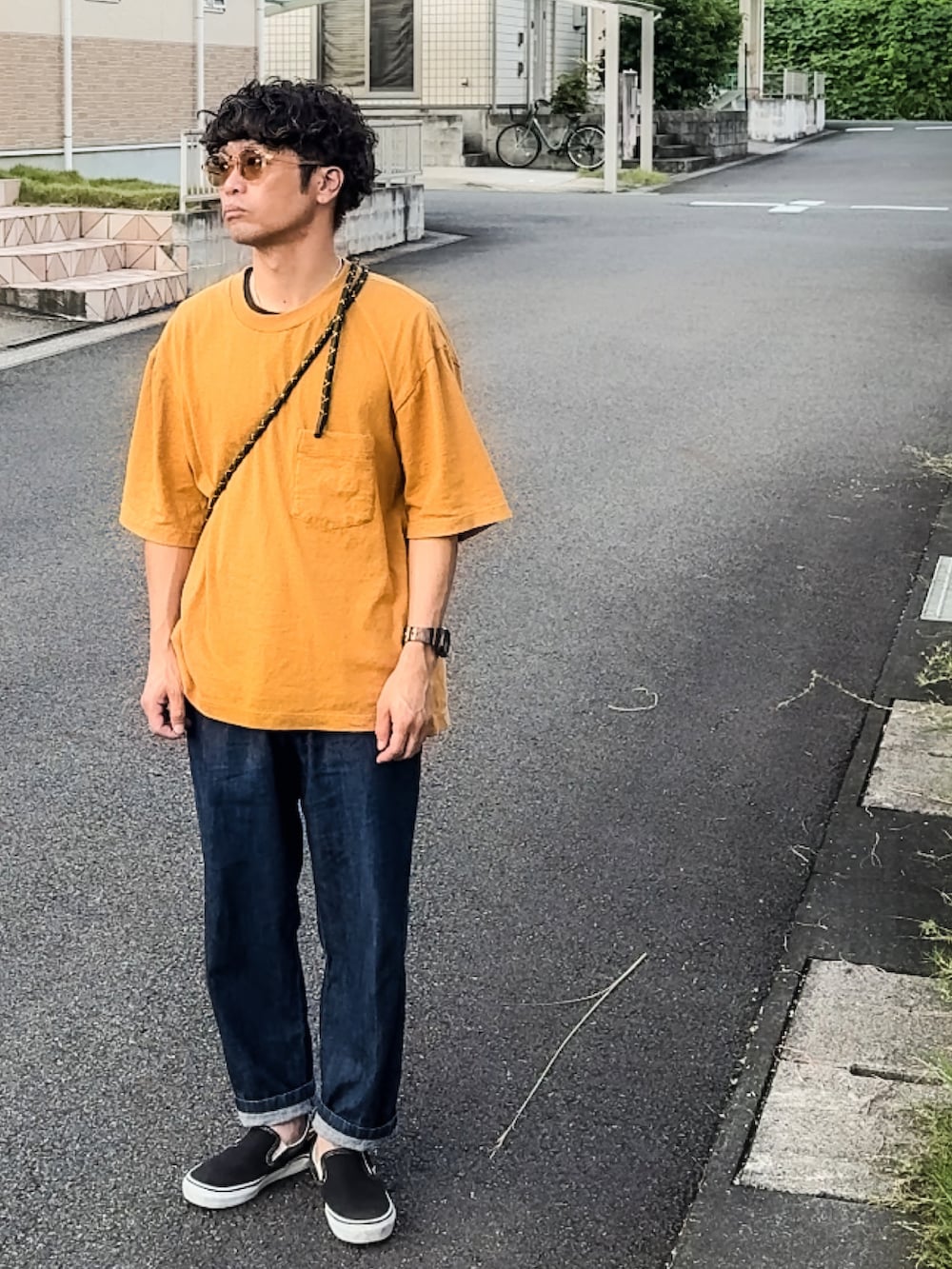 ブラック系のスリッポン、ブルー系のパンツ、イエロー系のTシャツ/カットソーを着用したメンズの秋コーディネートの2枚目の写真