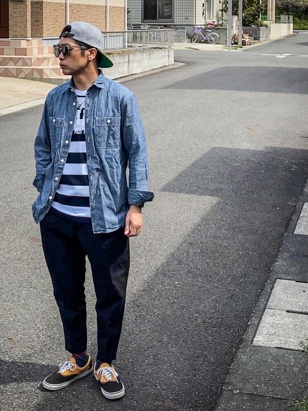 ホワイト系のTシャツ/カットソー、ブルー系のシャツ/ブラウス、ブラック系のスラックスを着用したメンズの春コーディネートの2枚目の写真