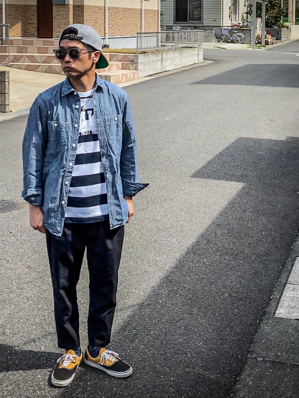 ホワイト系のTシャツ/カットソー、ブルー系のシャツ/ブラウス、ブラック系のスラックスを着用したメンズの春コーディネートの3枚目の写真