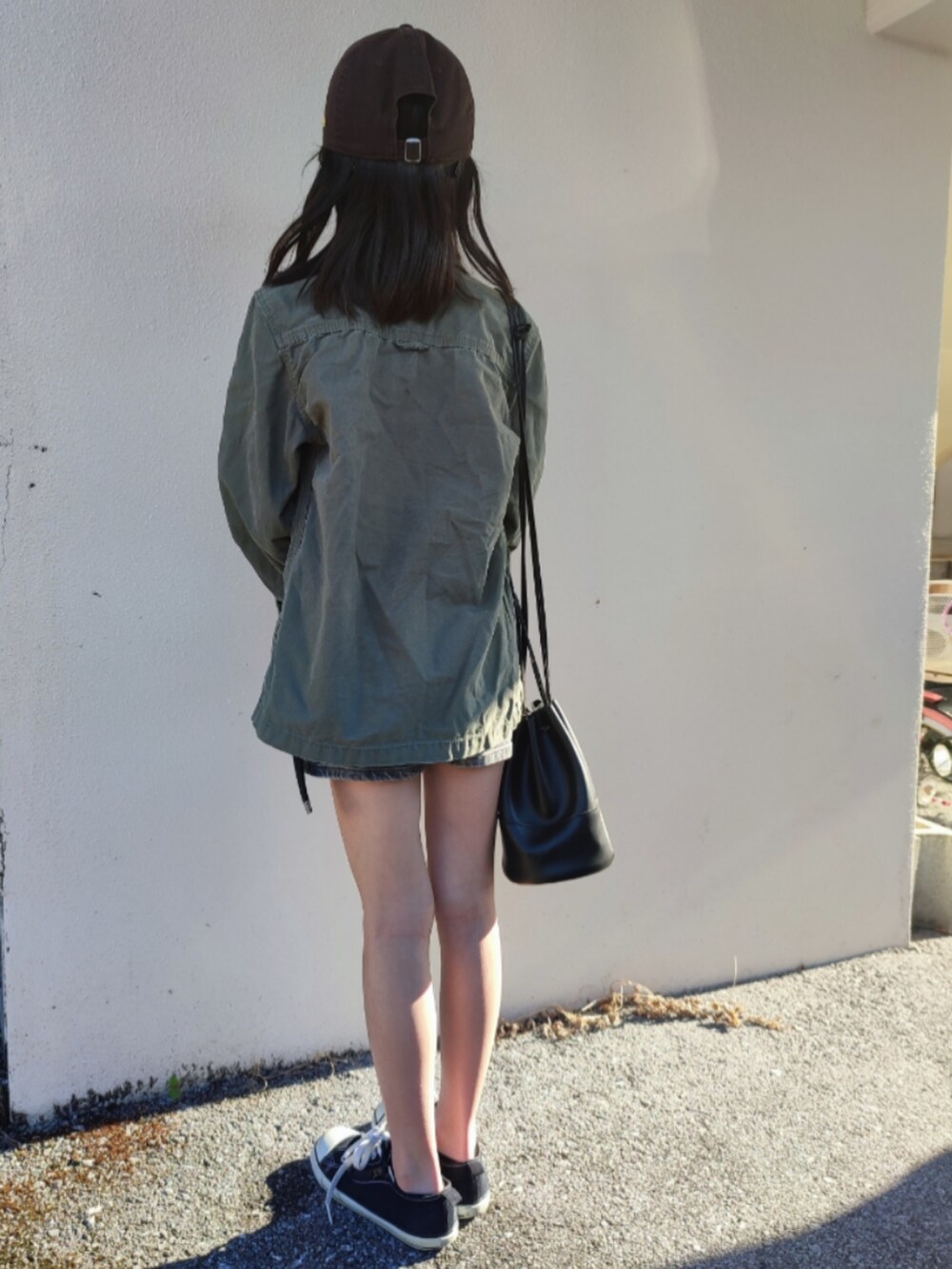 グリーン系のミリタリージャケット、ブルー系のデニムパンツ、ブラック系のスニーカーを着用したキッズの春コーディネートの4枚目の写真