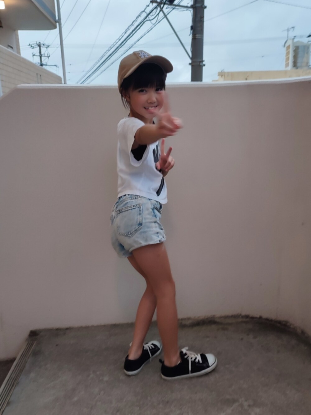 ホワイト系のTシャツ/カットソー、ブルー系のデニムパンツ、ブラック系のスニーカーを着用したキッズの春コーディネートの5枚目の写真