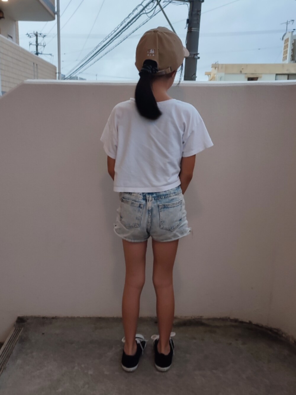 ホワイト系のTシャツ/カットソー、ブルー系のデニムパンツ、ブラック系のスニーカーを着用したキッズの春コーディネートの3枚目の写真