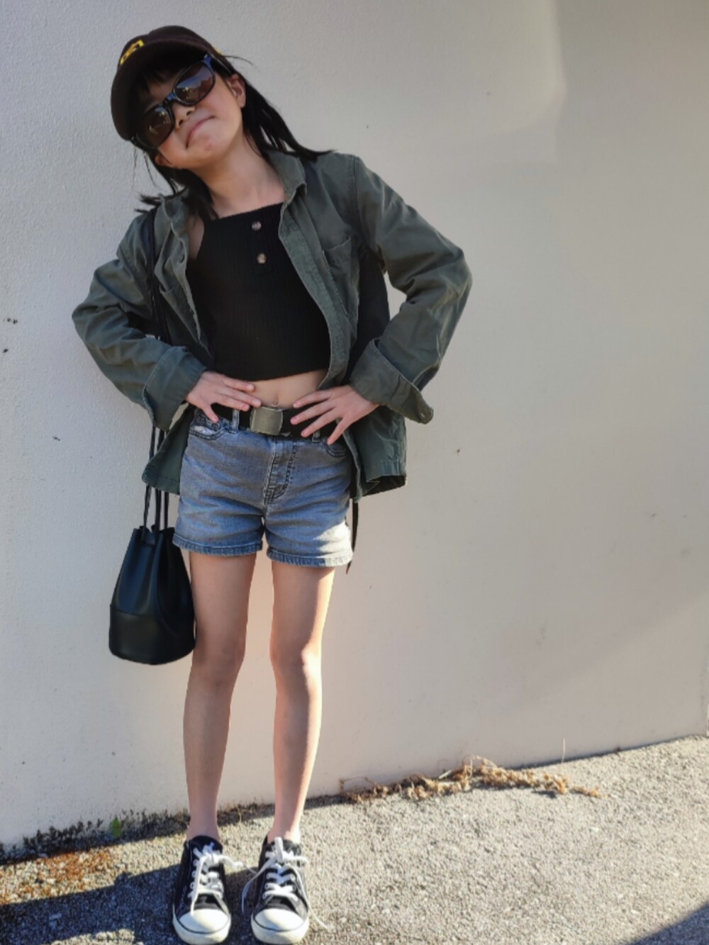 グリーン系のミリタリージャケット、ブルー系のデニムパンツ、ブラック系のスニーカーを着用したキッズの春コーディネートの5枚目の写真