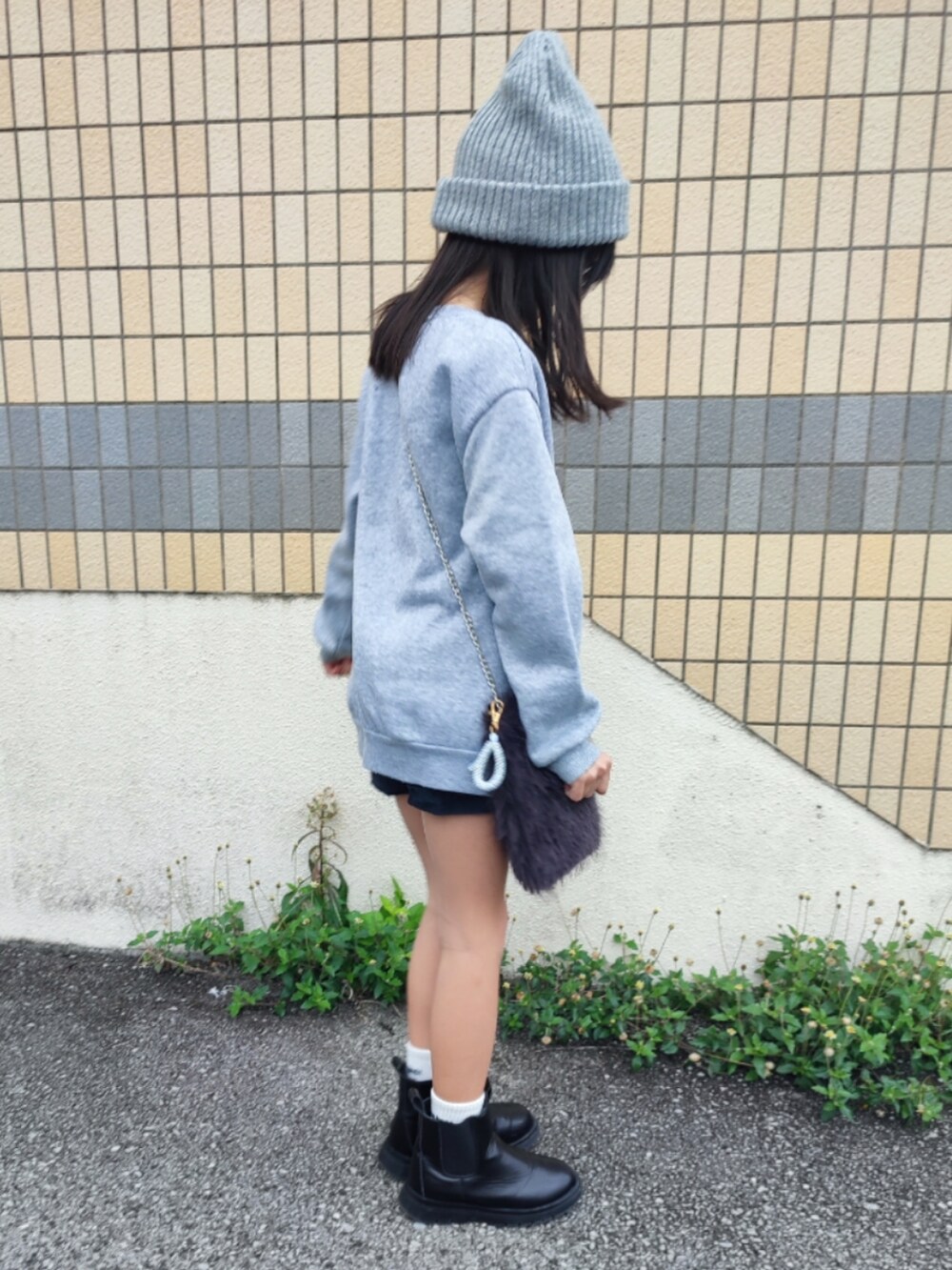 グレー系のスウェット、ブラック系のブーツ、グレー系のショルダーバッグを着用したキッズの冬コーディネートの2枚目の写真