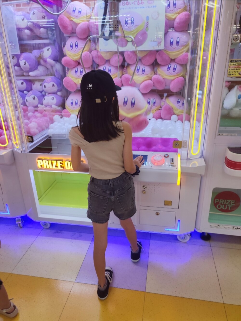 ベージュ系のタンクトップ、グレー系のデニムパンツ、ブラック系のスニーカーを着用したキッズの夏コーディネートの5枚目の写真