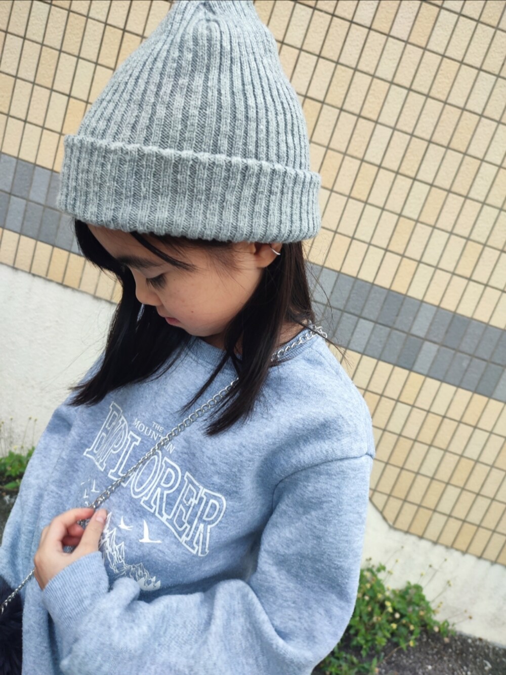 グレー系のスウェット、ブラック系のブーツ、グレー系のショルダーバッグを着用したキッズの冬コーディネートの3枚目の写真