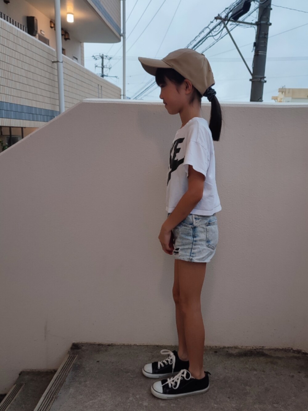 ホワイト系のTシャツ/カットソー、ブルー系のデニムパンツ、ブラック系のスニーカーを着用したキッズの春コーディネートの2枚目の写真