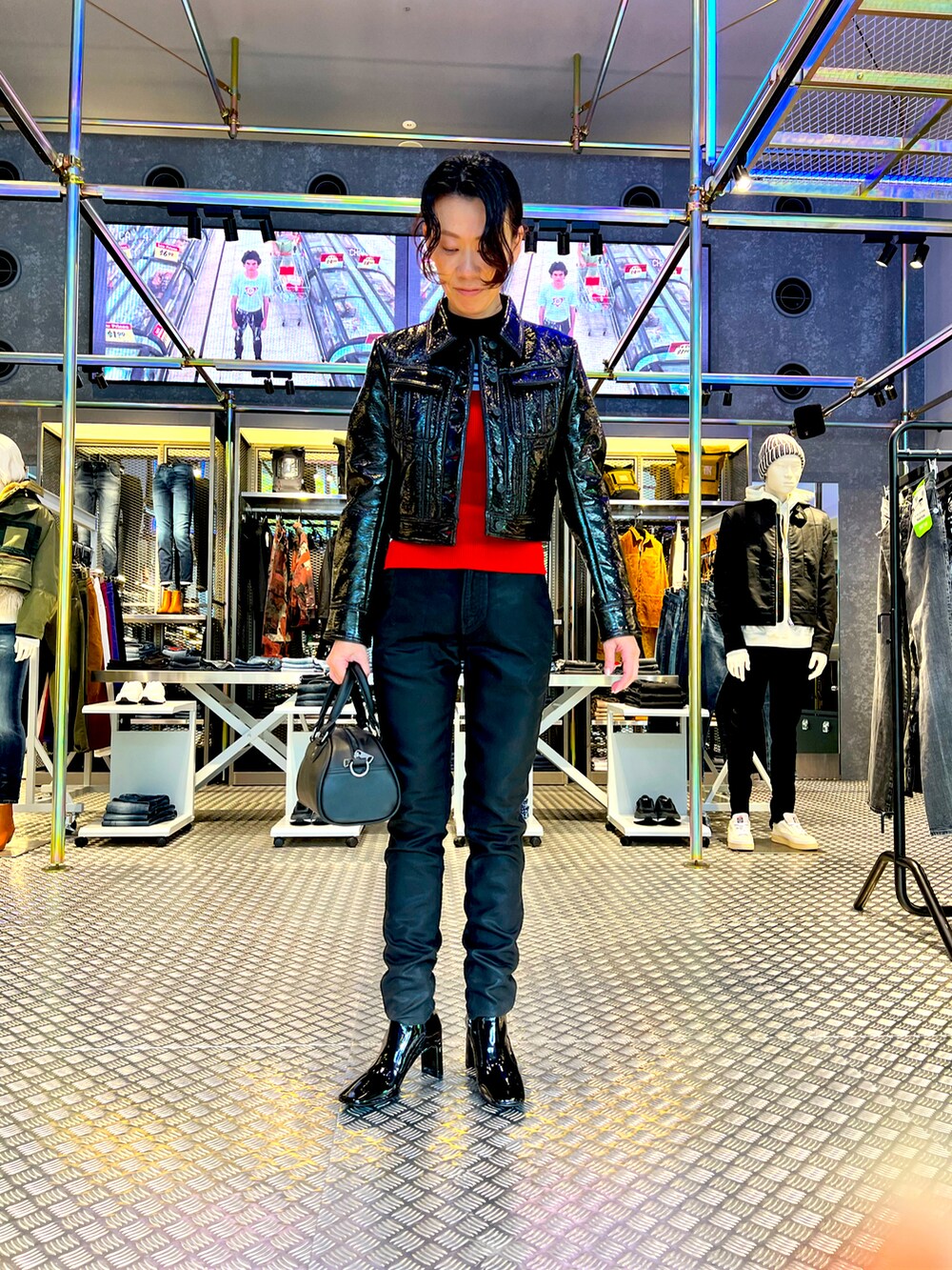 ブラック系のブルゾン、レッド系のニット/セーター、ブラック系のブーツを着用したレディースの秋コーディネートの2枚目の写真