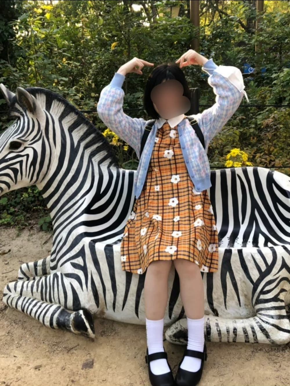 ブルー系のカーディガン/ボレロ、ブラック系のパンプス、ブラック系のバックパック/リュックを着用したレディースの春コーディネートの2枚目の写真