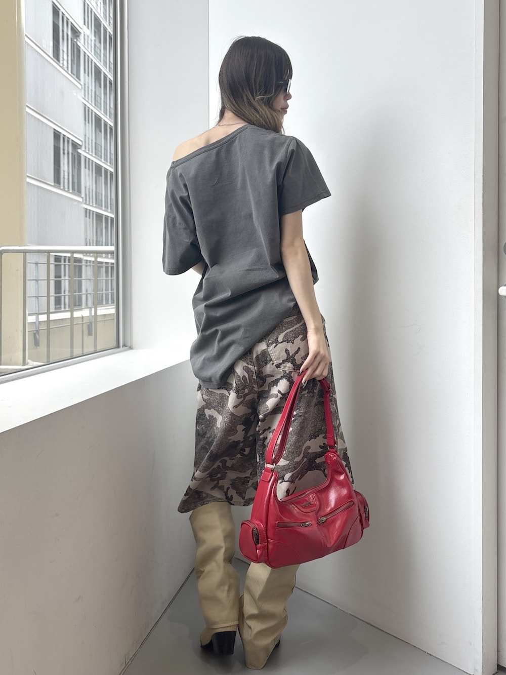 グレー系のワンピース、その他のデニムパンツ、レッド系のショルダーバッグを着用したレディースの春コーディネートの3枚目の写真