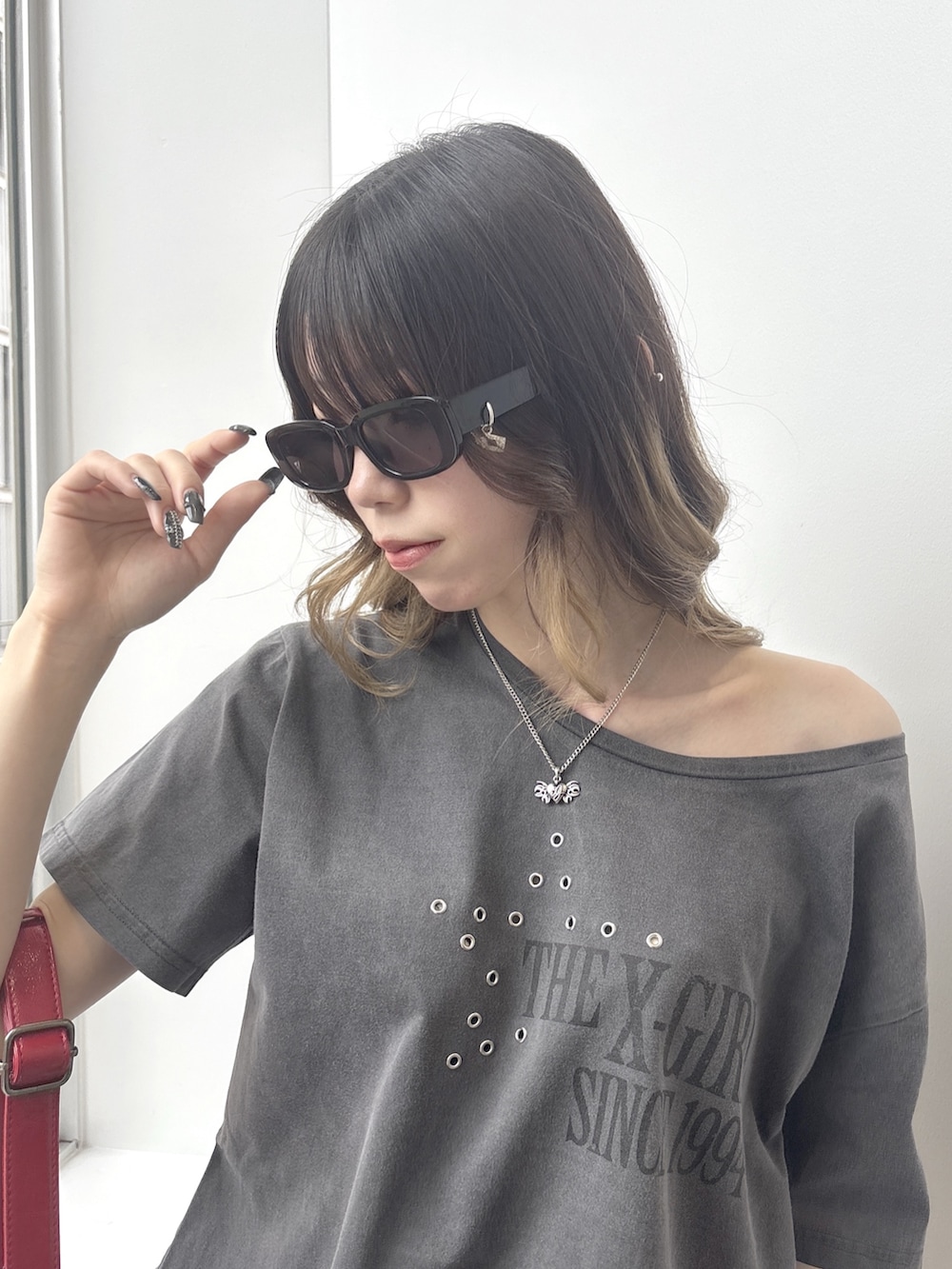 グレー系のワンピース、その他のデニムパンツ、レッド系のショルダーバッグを着用したレディースの春コーディネートの4枚目の写真