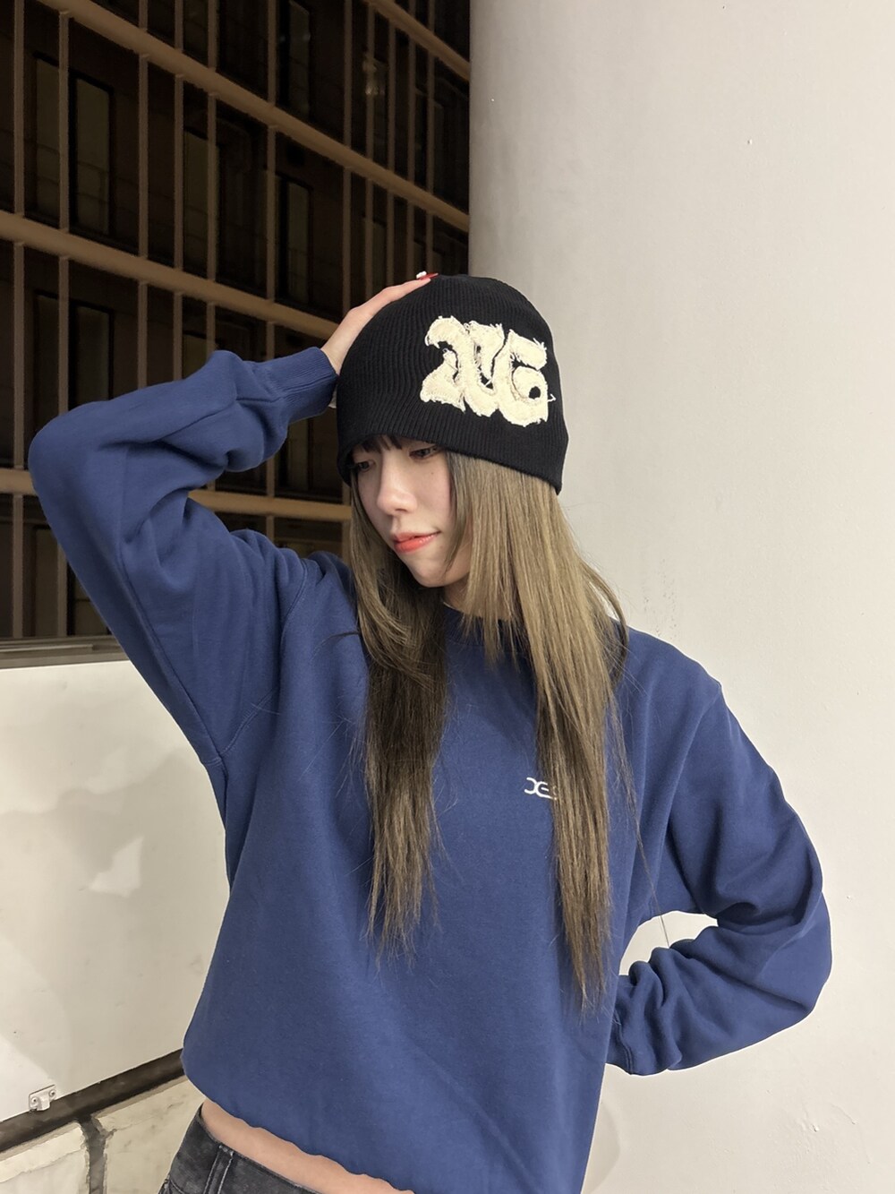 ブルー系のスウェット、ブラック系のデニムパンツ、ブラック系のニットキャップ/ビーニーを着用したレディースの秋コーディネートの4枚目の写真