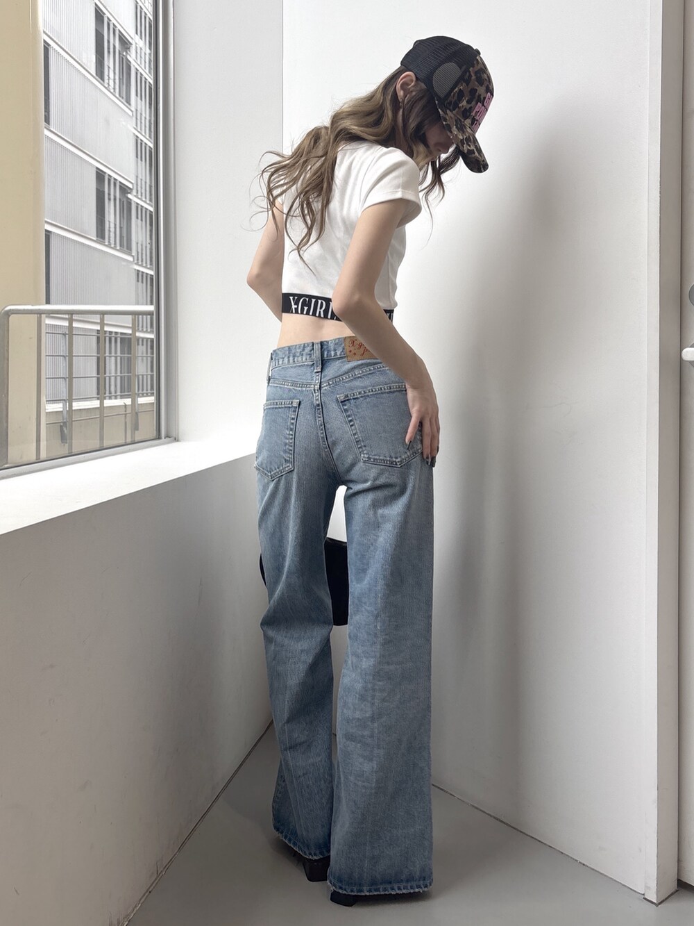 ブルー系のデニムパンツ、ブラック系のショルダーバッグ、ホワイト系のTシャツ/カットソーを着用したレディースの春コーディネートの3枚目の写真