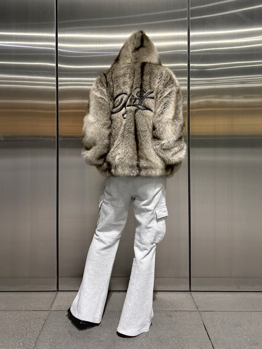 ホワイト系のTシャツ/カットソー、ブラウン系のブルゾン、グレー系のスウェットパンツを着用したレディースの秋コーディネートの3枚目の写真