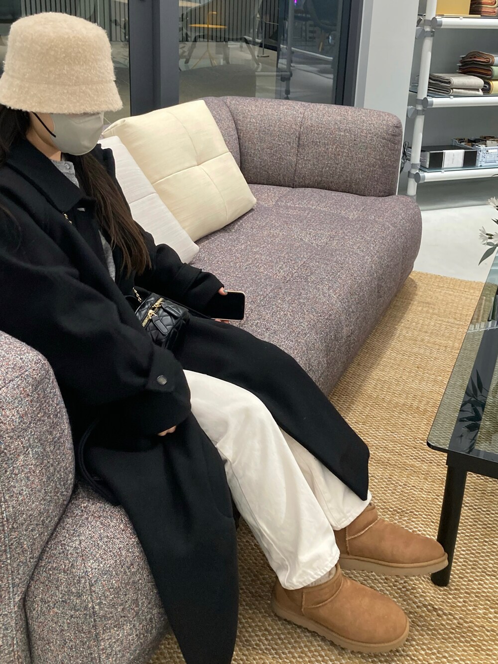 ブラック系のダウンジャケット/コート、ブラウン系のブーツ、ホワイト系のパンツを着用したレディースの冬コーディネートの2枚目の写真