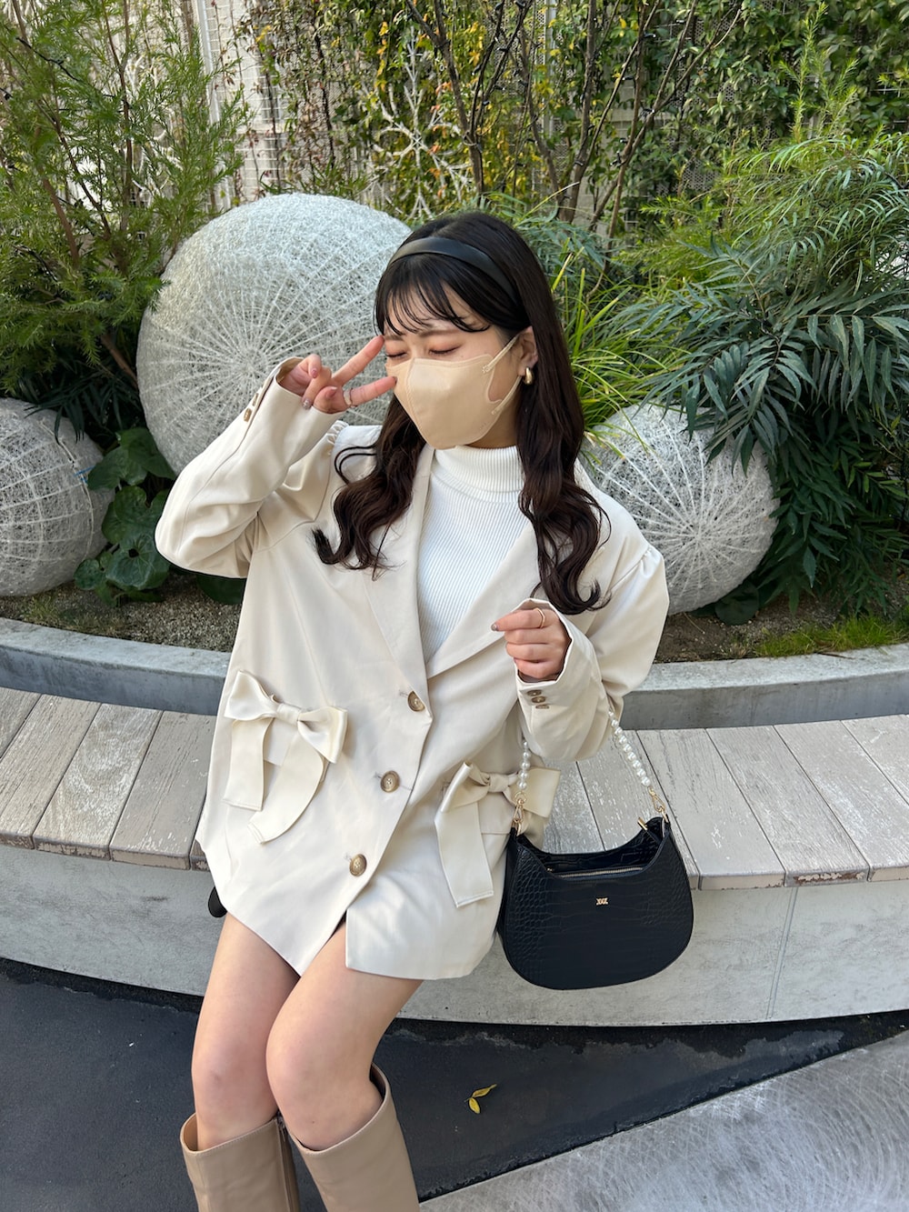 ホワイト系のテーラードジャケット、ホワイト系のTシャツ/カットソー、ブラック系のショルダーバッグを着用したレディースの冬コーディネートの2枚目の写真