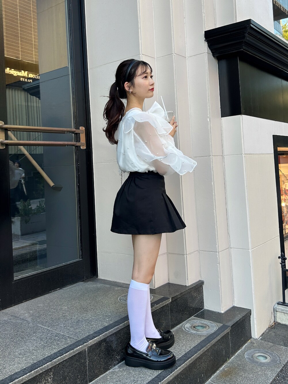 ホワイト系のシャツ/ブラウス、ブラック系のスカート、ブラック系のローファーを着用したレディースの秋コーディネートの2枚目の写真