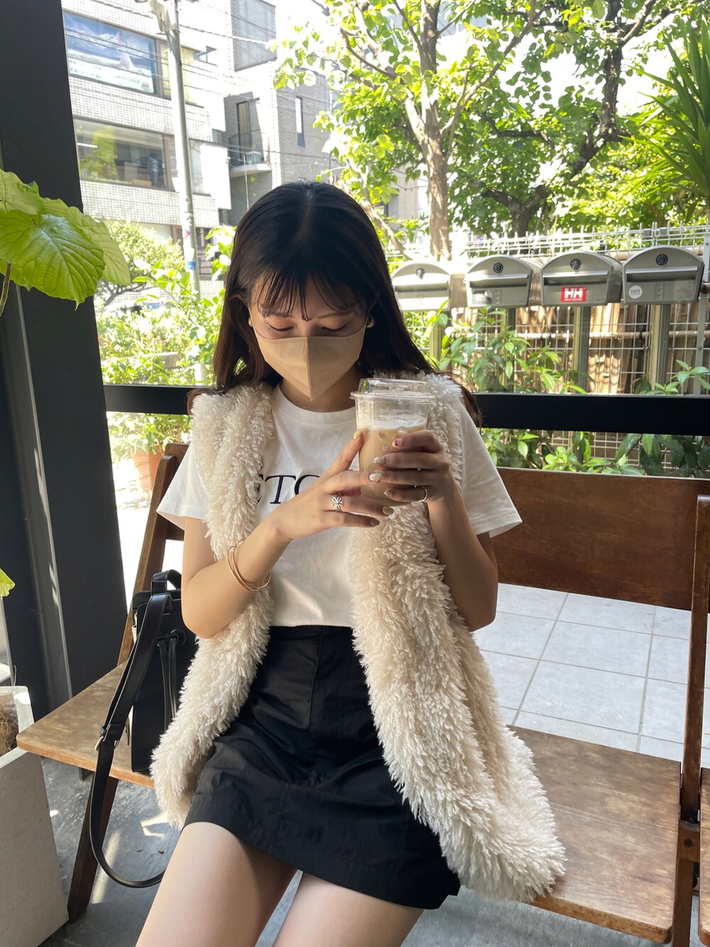 ブラック系のスカート、ホワイト系のベスト、ホワイト系のTシャツ/カットソーを着用したレディースの夏コーディネートの2枚目の写真